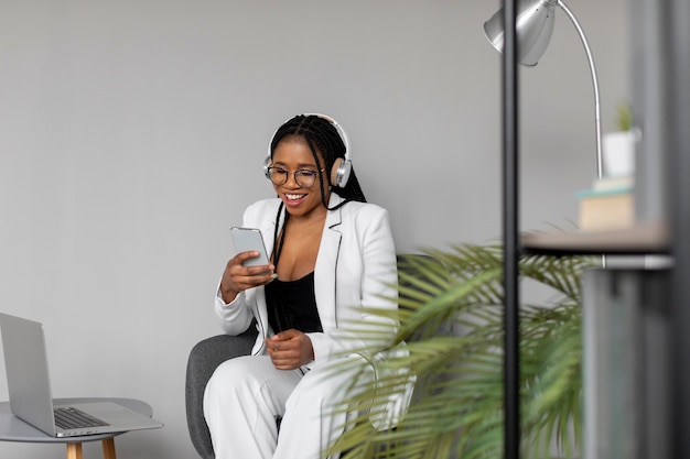 Foto gratuita donna del colpo medio al lavoro con il telefono