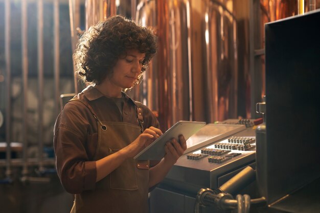 Medium shot woman working in beer factory