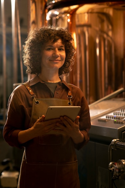 Medium shot woman working in beer factory