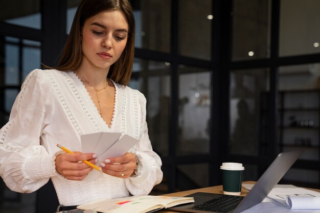 Foto gratuita donna del colpo medio che lavora alla scrivania