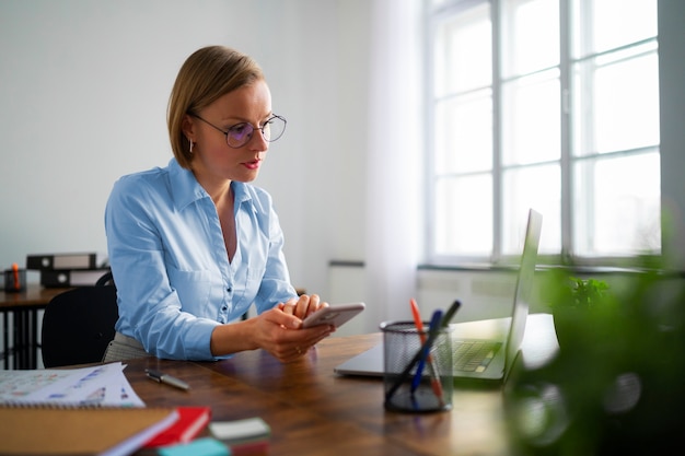 Free photo medium shot woman working at desk