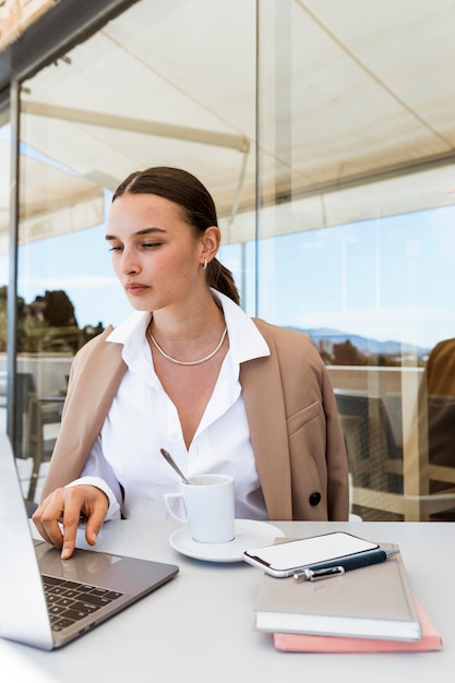 Foto gratuita donna del colpo medio che lavora al computer portatile