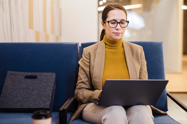 Medium shot woman working on laptop