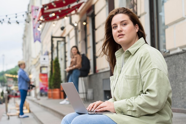 Foto gratuita donna del colpo medio che lavora al computer portatile