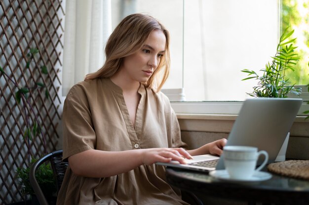 Medium shot woman working on laptop