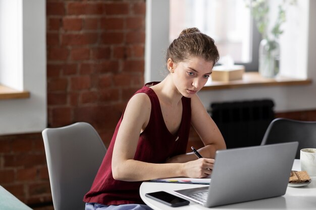 노트북에서 작업하는 중간 샷 여성