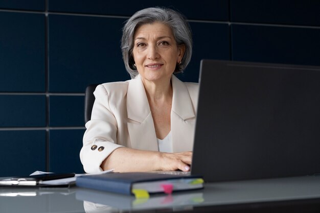 Medium shot woman working on laptop