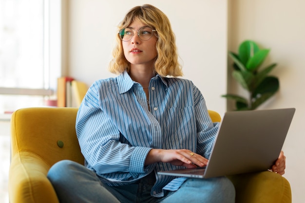 Free photo medium shot woman working on laptop