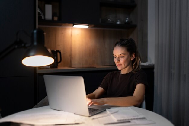 Medium shot woman working on laptop