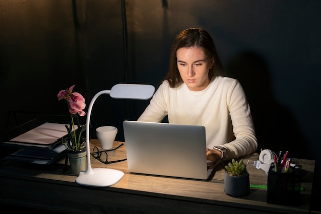 Medium shot woman working late at night