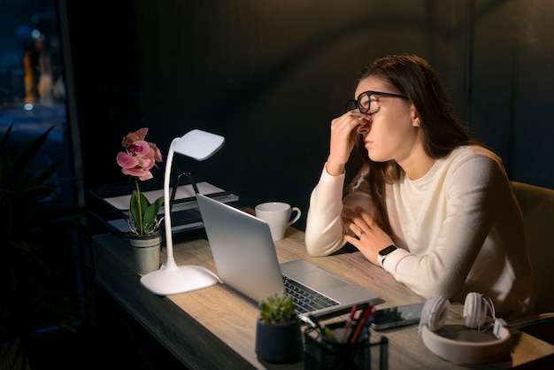 Foto gratuita donna di tiro medio che lavora a tarda notte