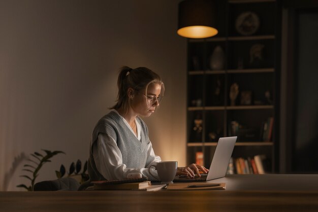 Medium shot woman working late at night