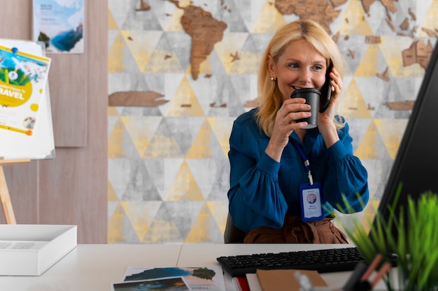 Medium shot woman working in the office of a travel agency