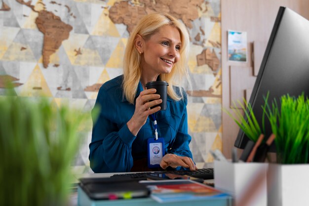 Free photo medium shot woman working in the office of a travel agency