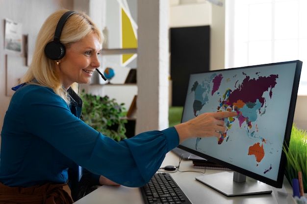 Free photo medium shot woman working in the office of a travel agency