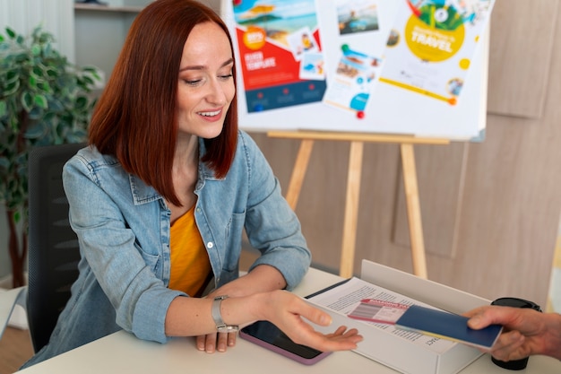 Medium shot woman working in the office of a travel agency