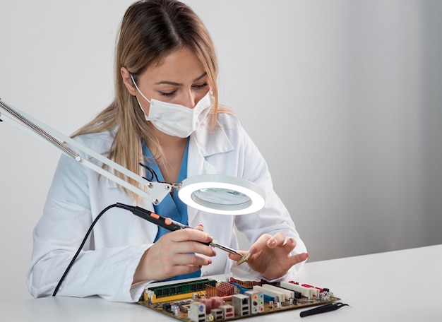 Foto gratuita donna del colpo medio che lavora nella tecnologia