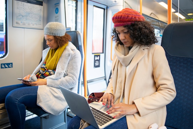 電車の中で働くミディアムショットの女性