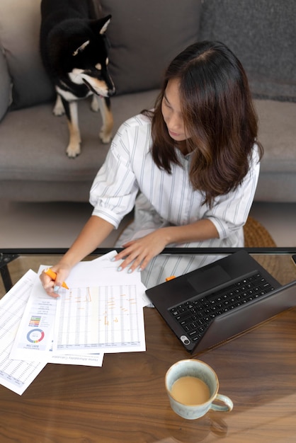 Foto gratuita donna del colpo medio che lavora con il cane a casa