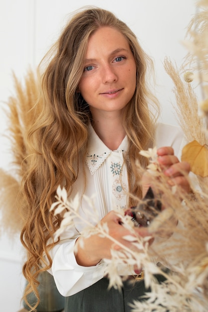 Medium shot woman working with dried flowers