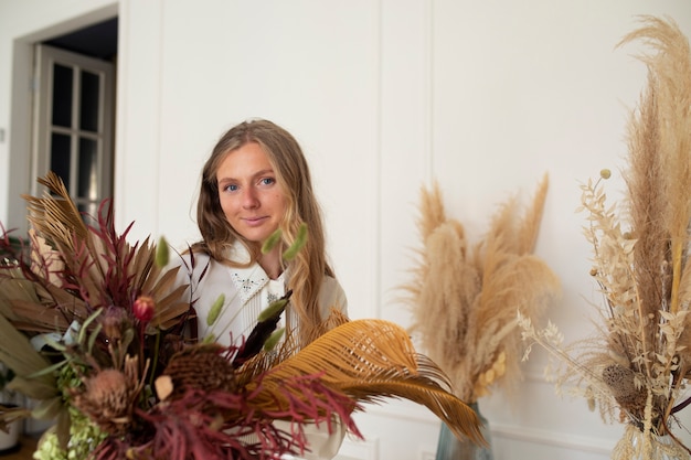 Medium shot woman working with dried flowers