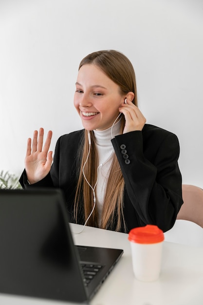 Donna del colpo medio che lavora con gli auricolari