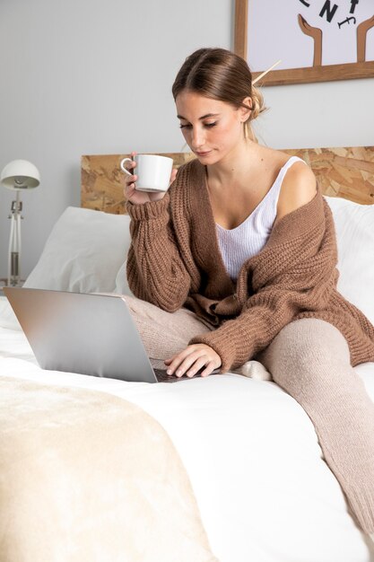 Medium shot woman working with laptop