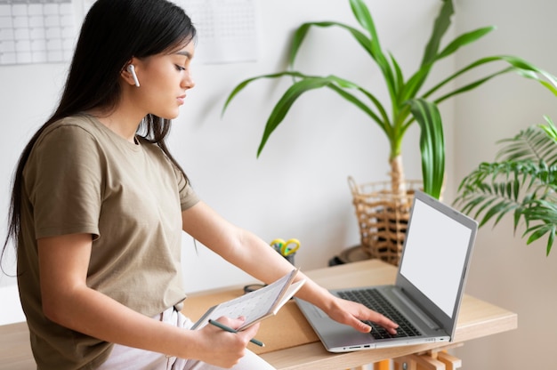 Medium shot woman working with laptop