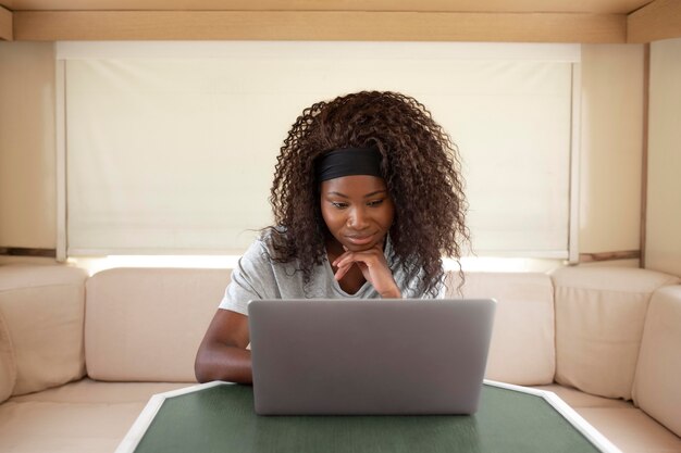 Medium shot woman working with laptop