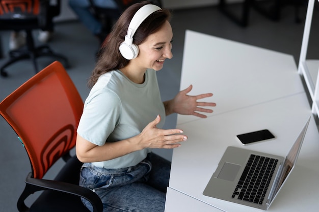 Medium shot woman working with laptop