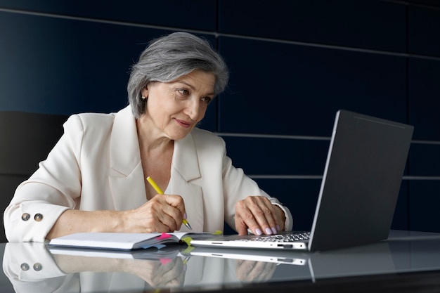 Medium shot woman working with laptop