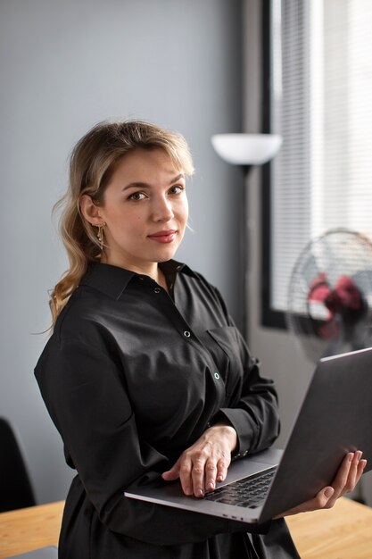 Medium shot woman working with laptop