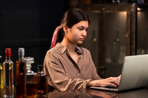 medium shot woman working with laptop