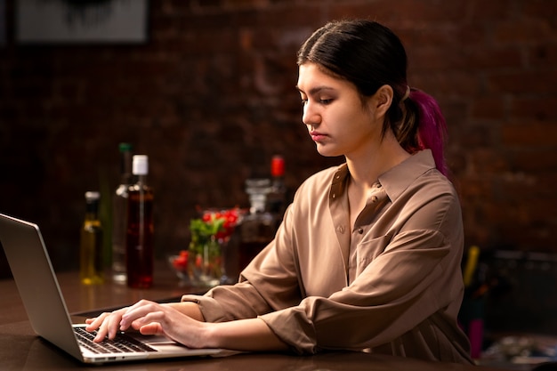 Medium shot woman working with laptop