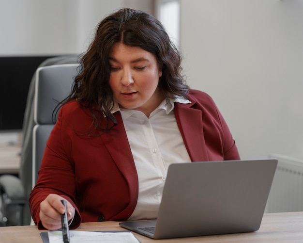 Medium shot woman working with laptop
