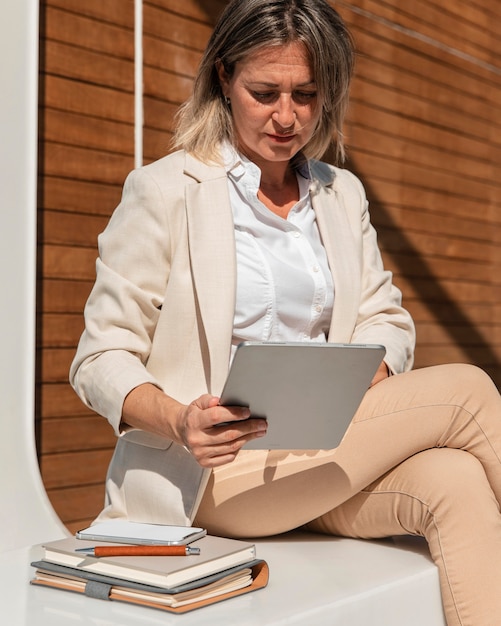 Medium shot woman working with tablet