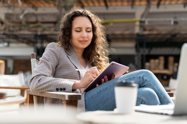 Medium shot woman working with tablet