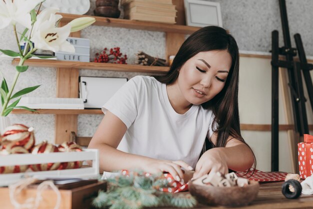 Medium shot woman wrapping paper at home