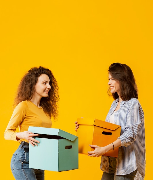 Medium shot of women carrying boxes