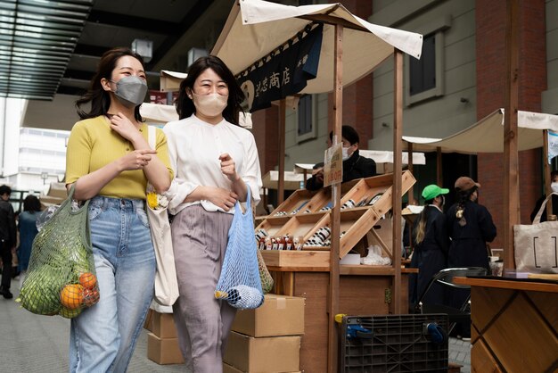 Medium shot women carrying groceries in tote bag