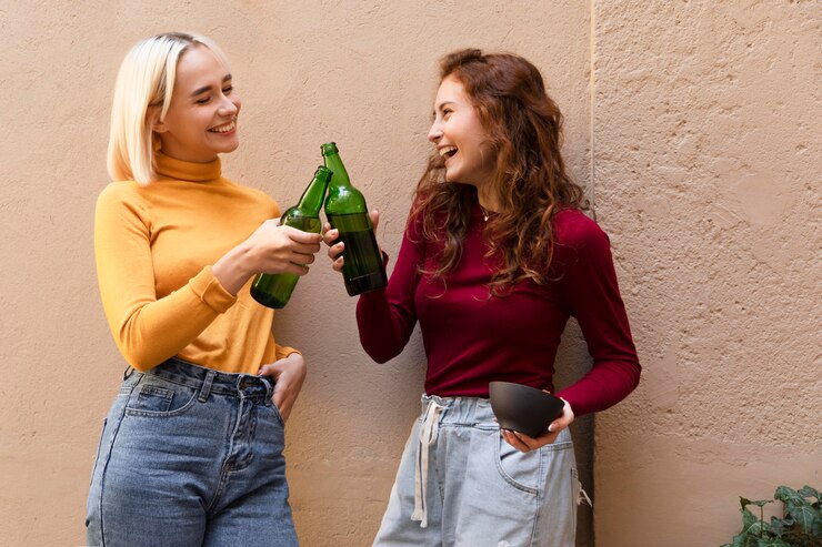 Free Photo medium shot women clinking bottles