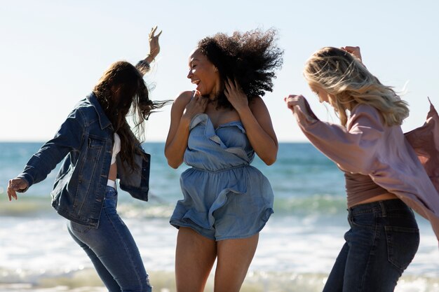Medium shot women dancing at beach