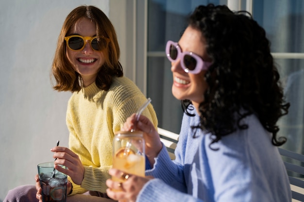 Free photo medium shot women drinking kombucha