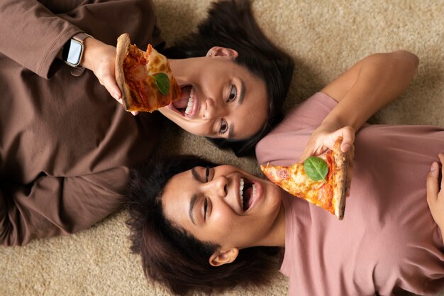 Medium shot women eating delicious pizza