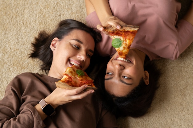 Foto gratuita donne del piano medio che mangiano pizza deliziosa