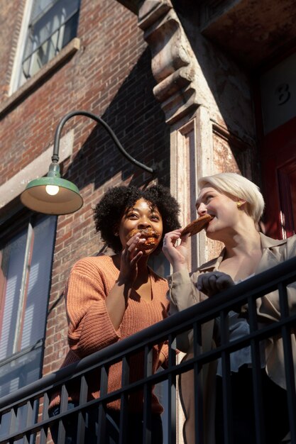 Medium shot women eating pastry