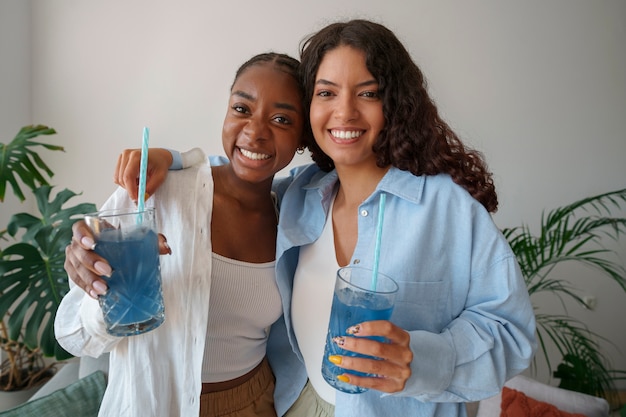 Free photo medium shot women enjoying blue matcha at home