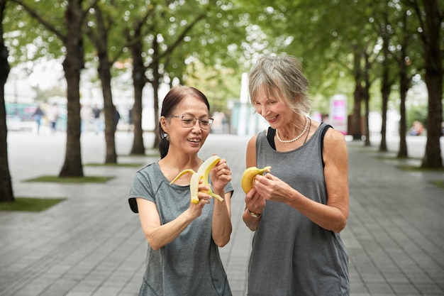 Free photo medium shot women holding bananas