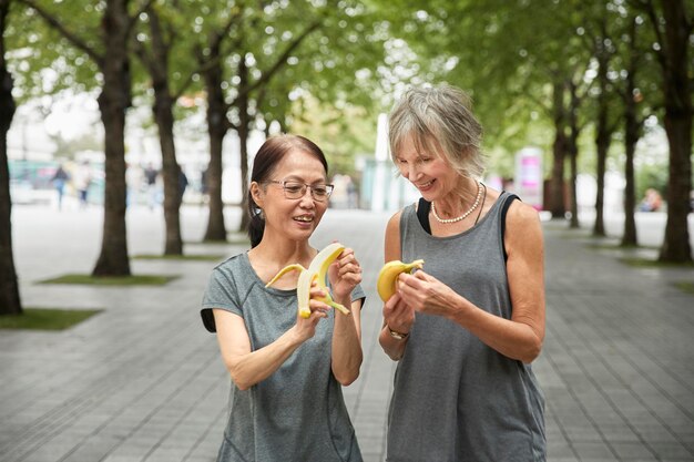 Medium shot women holding bananas