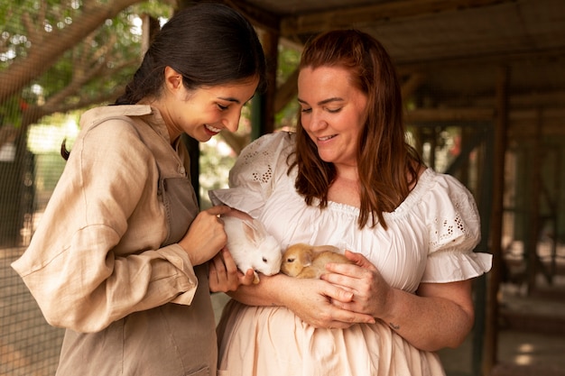 Free photo medium shot women holding bunnies